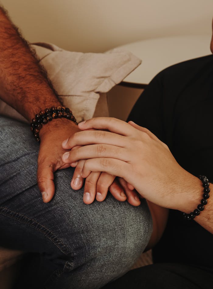 A close-up of two hands holding, symbolizing support and compassion.